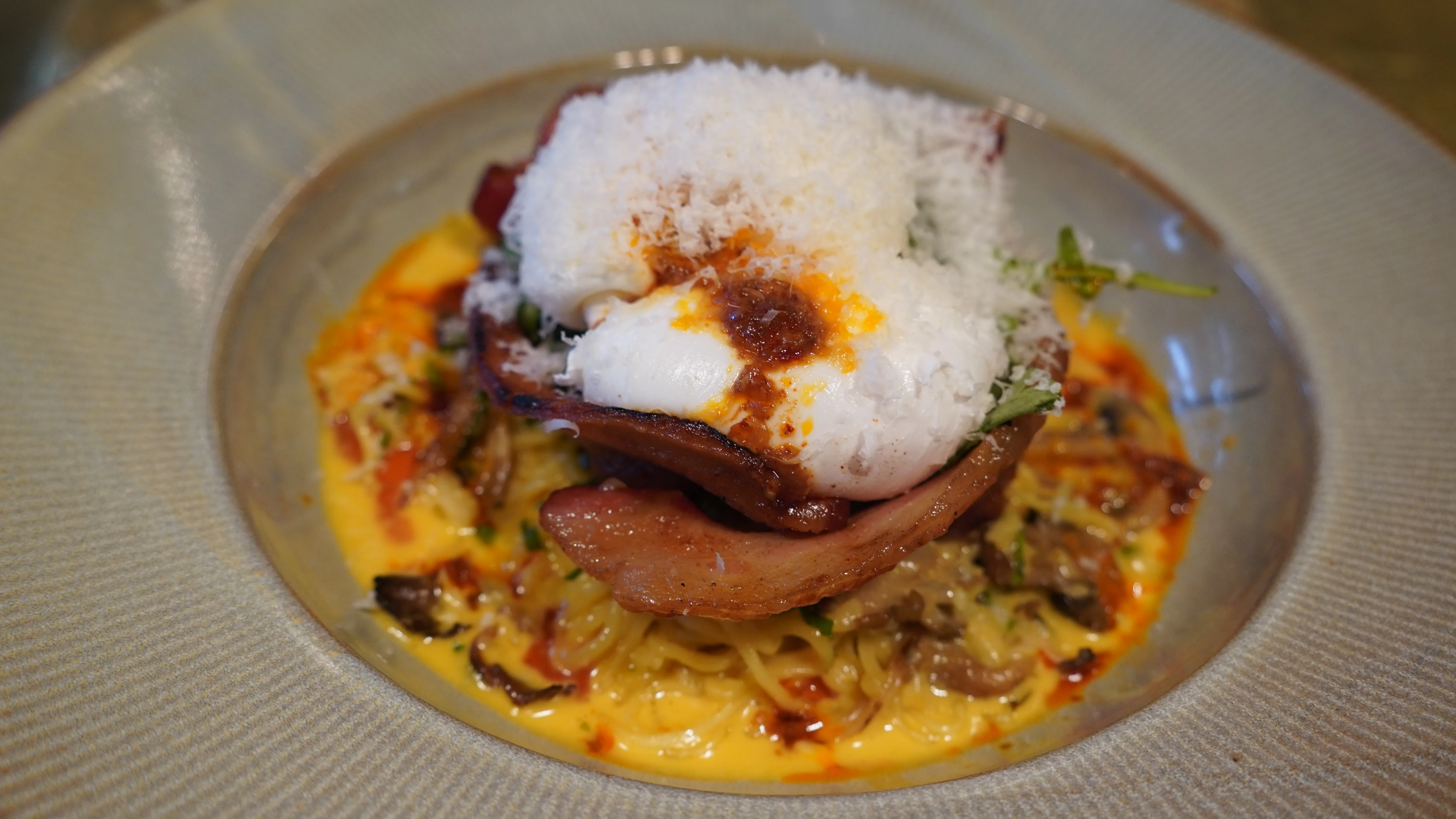 Thick-cut bacon, creamy pasta and a poached egg from weekend brunch at notable - The Steakhouse, Calgary